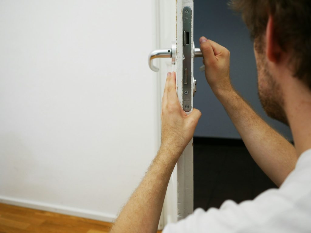 Serrurier installant une serrure à mortaise sur une porte d’intérieur